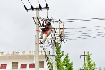 在烈日下登桿作業，更換10千伏線路懸式絕緣子